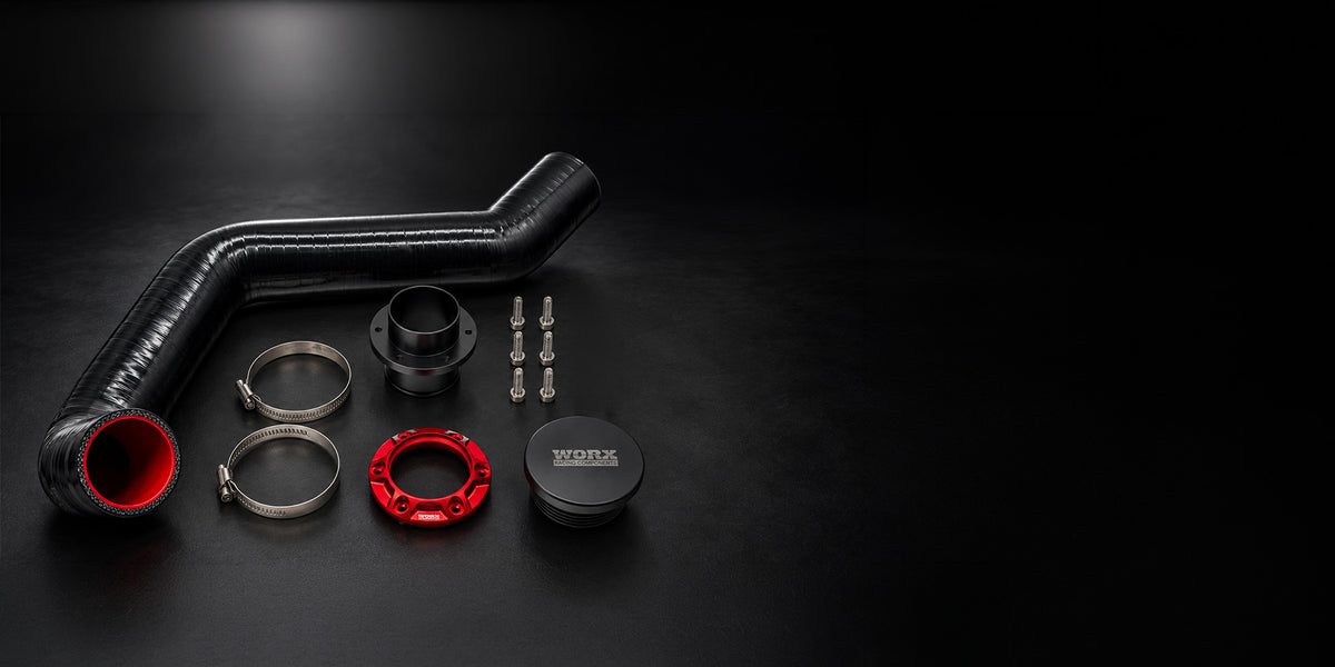 Contents of the WORX Seadoo Spark rear exit exhaust kit: silicone hose, two hose clamps, bulkhead, red anodised outlet ring, six bolts and block off plate